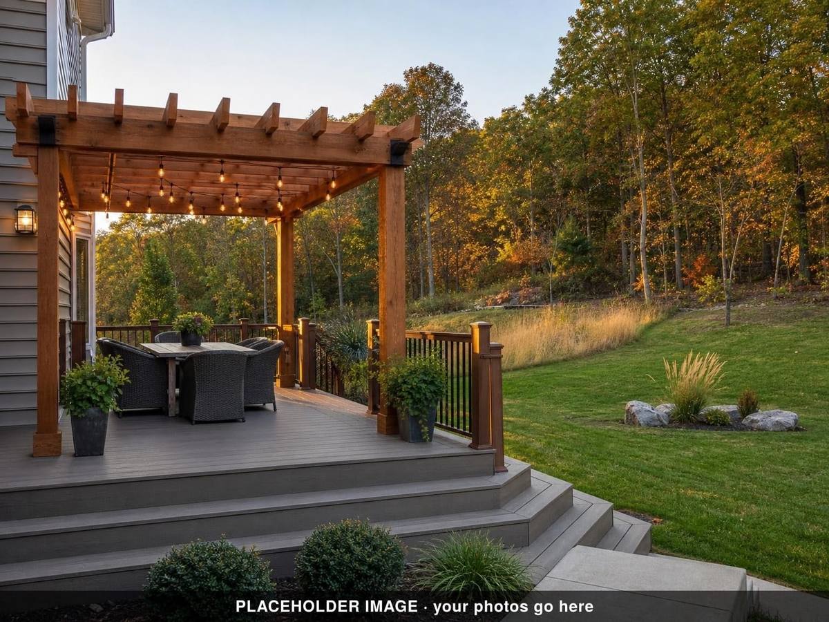 Composite deck under a wood pergola with string lights and wicker dining set at dusk (placeholder image)