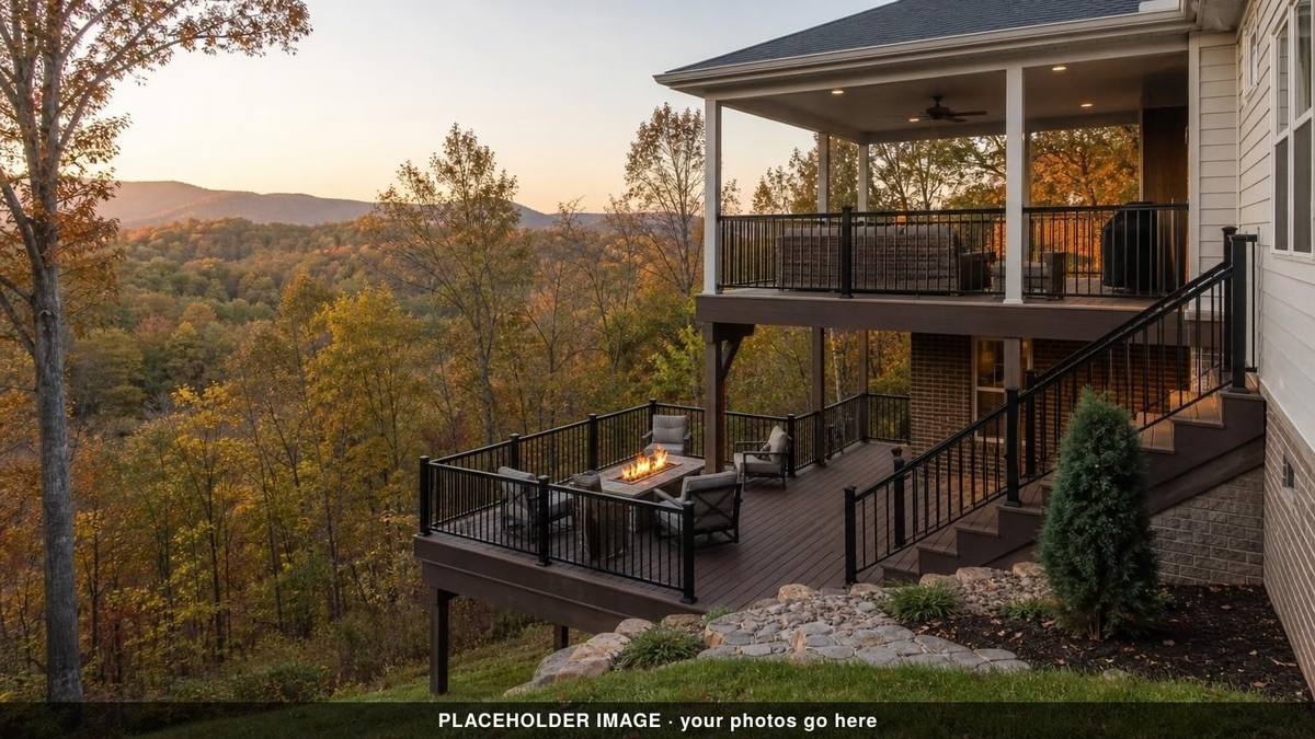 Multi-level deck with fire table and black railings below a covered porch, autumn hills at dusk (placeholder image)